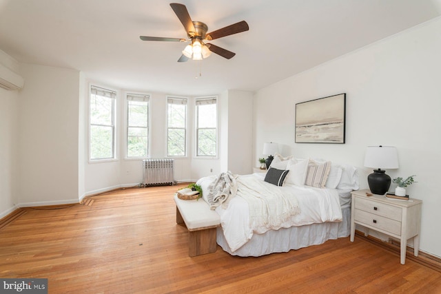 2638 E Baltimore St, Baltimore, MD 21224 - bedroom with radiator heating unit, light wood-style flooring, baseboards, and ceiling fan