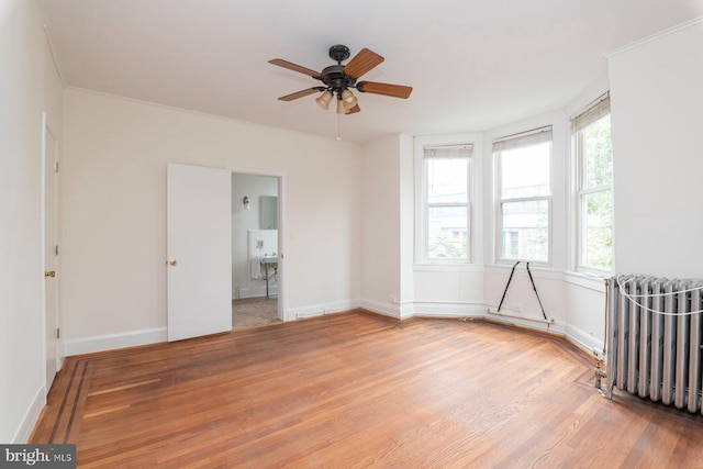 2638 E Baltimore St, Baltimore, MD 21224 - unfurnished room with radiator, wood finished floors, a ceiling fan, and baseboards