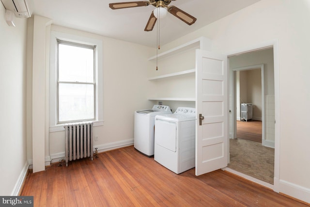 2638 E Baltimore St, Baltimore, MD 21224 - laundry room with radiator heating unit, washing machine and clothes dryer, light wood-type flooring, ceiling fan, and baseboards