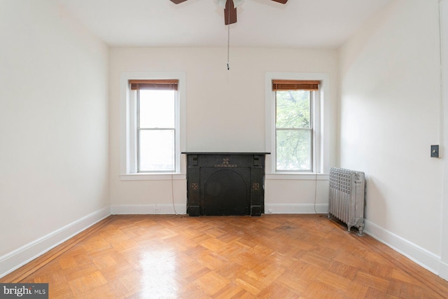 2638 E Baltimore St, Baltimore, MD 21224 - unfurnished living room with radiator heating unit, baseboards, ceiling fan, and a fireplace