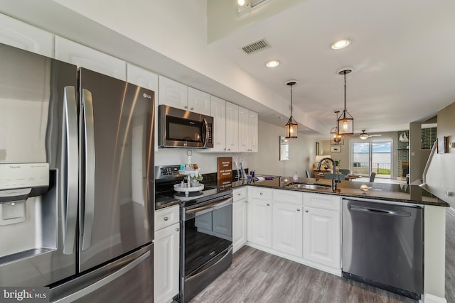 15 Queen Anne Way Unit E, Chester, MD 21619 - kitchen with stainless steel appliances, a sink, a peninsula, wood finished floors, and white cabinets