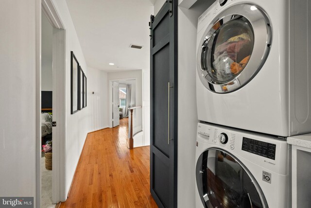 10000 Manor Pl, Fairfax, VA 22032 - laundry area with estacked washer and dryer, a barn door, light wood-style flooring, and recessed lighting