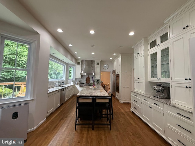 10000 Manor Pl, Fairfax, VA 22032 - kitchen with wall chimney exhaust hood, white cabinetry, dark wood finished floors, glass insert cabinets, and recessed lighting