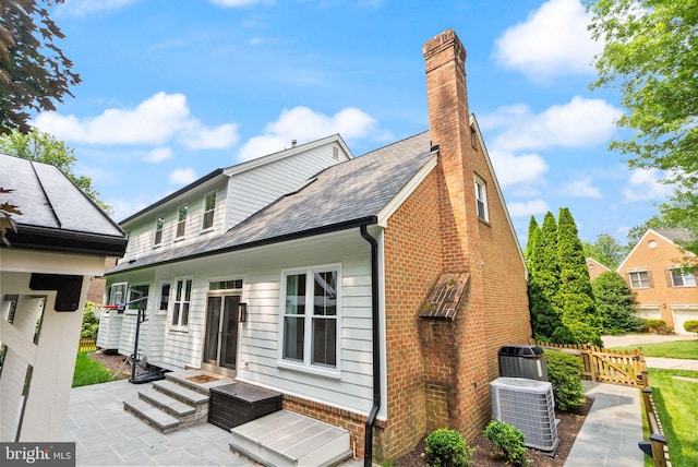 10000 Manor Pl, Fairfax, VA 22032 - back of property with central AC unit, brick siding, a patio area, and a chimney