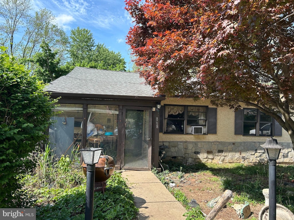 868 Tyson Ave, Abington, PA 19001 - view of front of house featuring roof with shingles, stone siding, a sunroom, and cooling unit