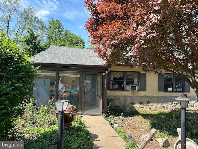 868 Tyson Ave, Abington, PA 19001 - view of front of house featuring roof with shingles, stone siding, a sunroom, and cooling unit