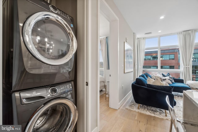 646 H St NE Unit 405, Washington, DC 20002 - washroom featuring stacked washing machine and dryer, wood finished floors, baseboards, and recessed lighting