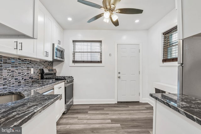 1936 S Sartain St, Philadelphia, PA 19148 - kitchen with appliances with stainless steel finishes, light wood-style flooring, dark stone countertops, backsplash, and white cabinets