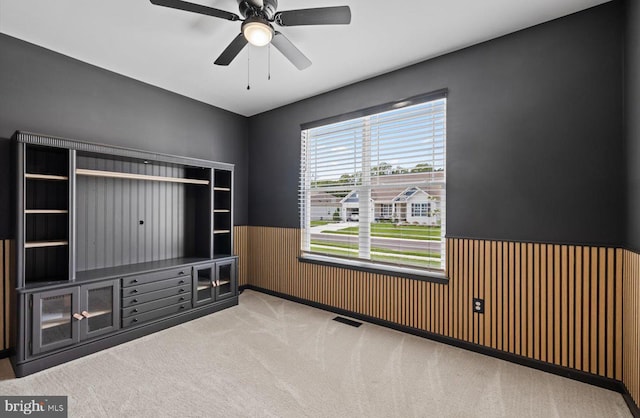 25040 Treeview Ln, Lewes, DE 19958 - spare room featuring a wainscoted wall, carpet floors, a ceiling fan, and wooden walls