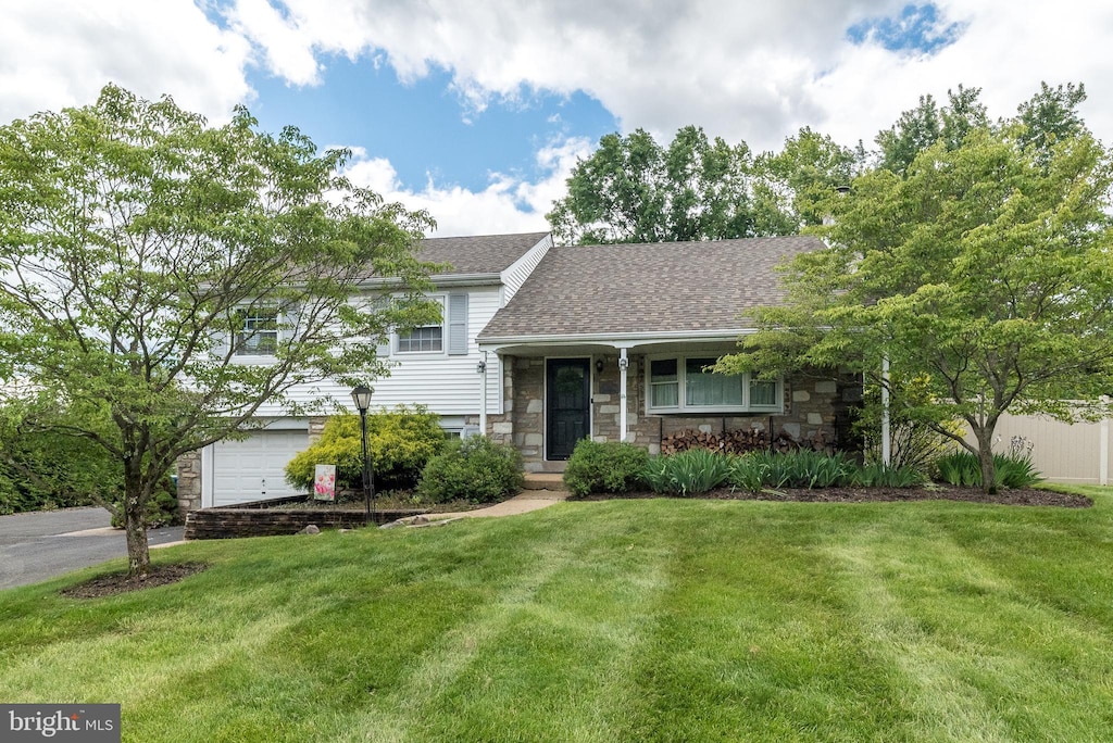 1612 Winding Dr, North Wales, PA 19454 - tri-level home featuring stone siding, an attached garage, a front lawn, and a shingled roof