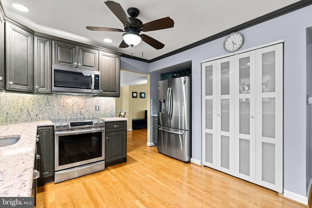 260 Whistling Pine Rd, Severna Park, MD 21146 - kitchen with appliances with stainless steel finishes, backsplash, light wood finished floors, a ceiling fan, and light stone counters