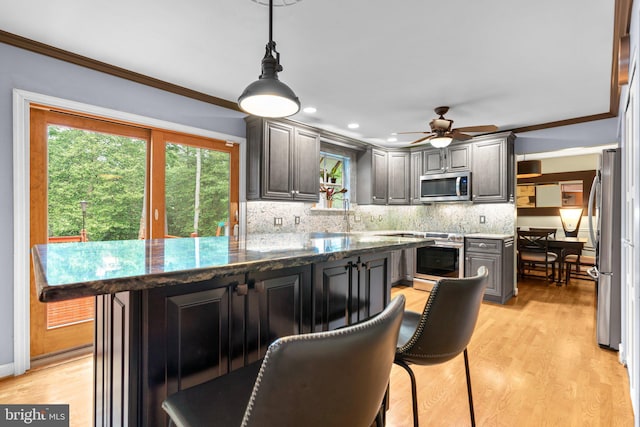 260 Whistling Pine Rd, Severna Park, MD 21146 - kitchen with stainless steel appliances, ornamental molding, backsplash, light wood finished floors, and a ceiling fan