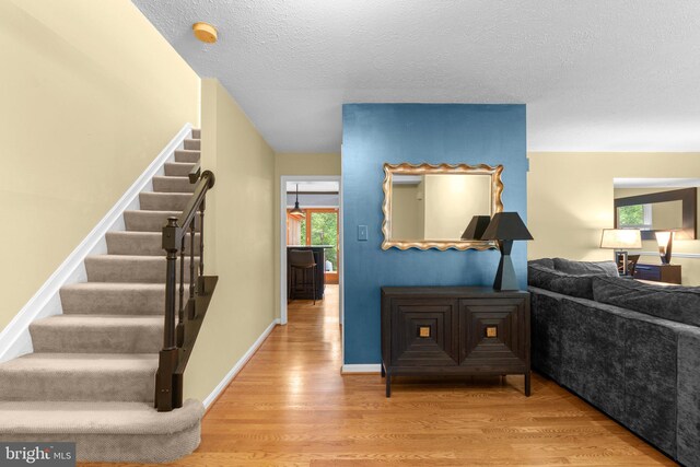 260 Whistling Pine Rd, Severna Park, MD 21146 - stairway featuring plenty of natural light, wood finished floors, and a textured ceiling