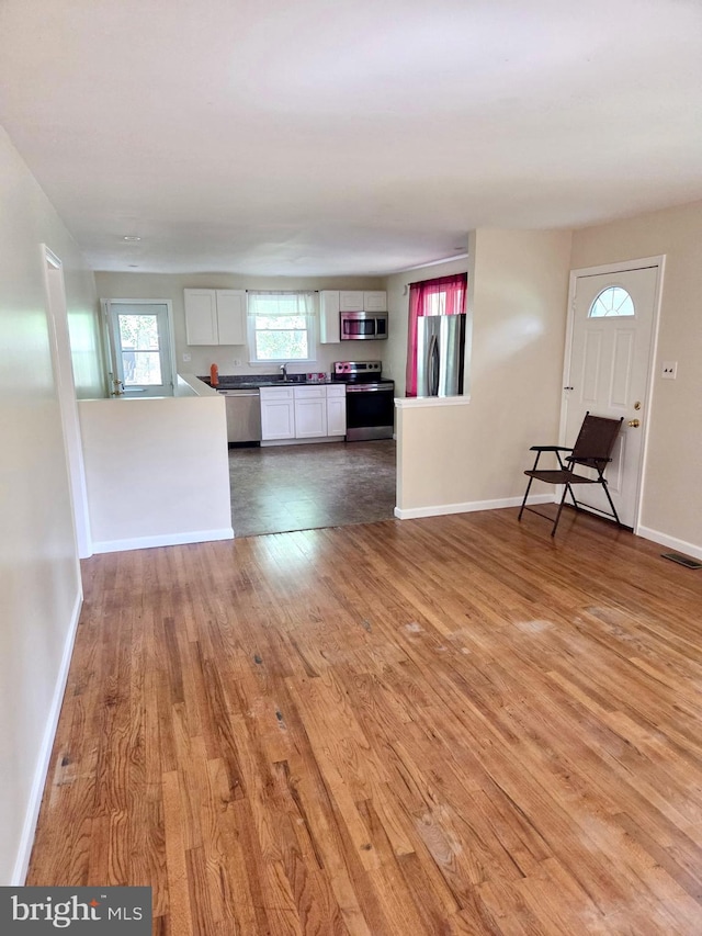 2404 Woodlea Dr, Joppa, MD 21085 - unfurnished living room featuring light wood-style flooring, baseboards, and a sink
