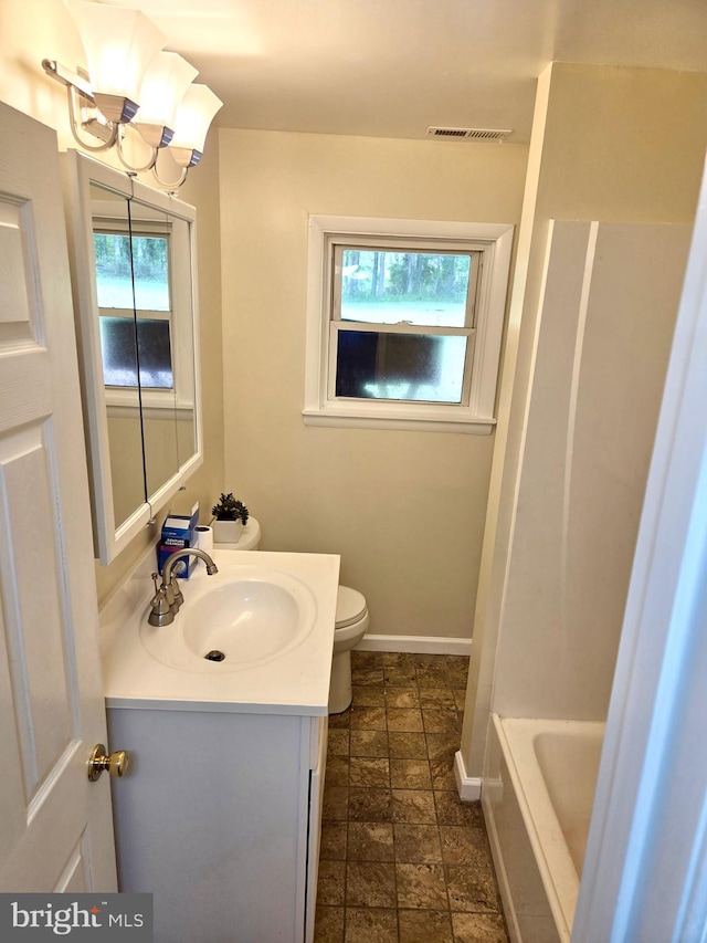 2404 Woodlea Dr, Joppa, MD 21085 - bathroom with healthy amount of natural light, vanity, stone tile floors, and toilet