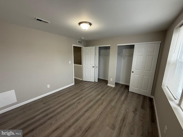 1727 Dallas St, Philadelphia, PA 19126 - unfurnished bedroom featuring two closets, dark wood-style flooring, and baseboards