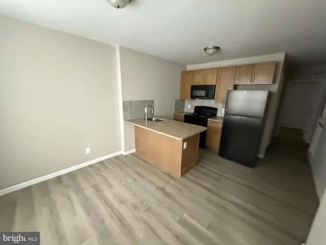 1727 Dallas St, Philadelphia, PA 19126 - kitchen with black appliances, a sink, a peninsula, light wood-style floors, and light countertops