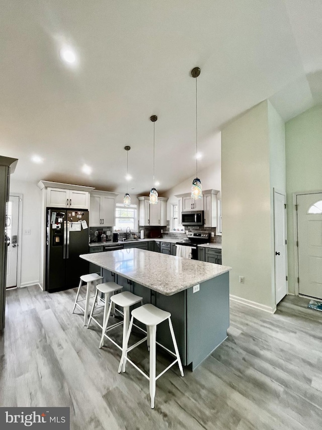 527 Monroe Bay Ave, Colonial Beach, VA 22443 - kitchen featuring appliances with stainless steel finishes, a sink, a center island, light wood-style floors, and baseboards