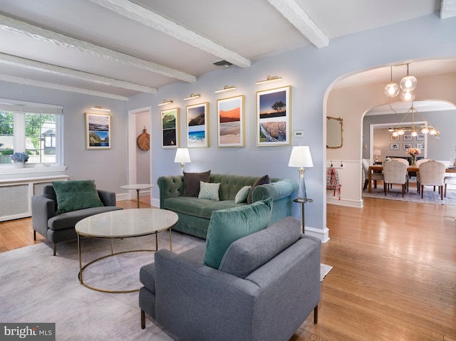 1204 Drexel Ave, Drexel Hill, PA 19026 - living room with arched walkways, light wood-style flooring, a chandelier, beamed ceiling, and baseboards