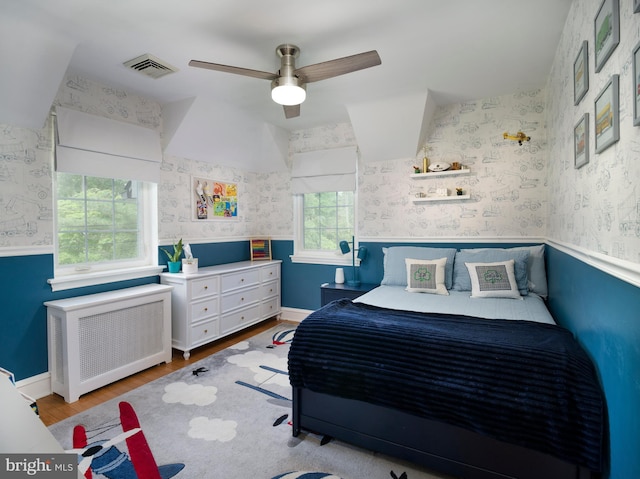 1204 Drexel Ave, Drexel Hill, PA 19026 - bedroom featuring radiator heating unit, wallpapered walls, wood finished floors, a wainscoted wall, and ceiling fan