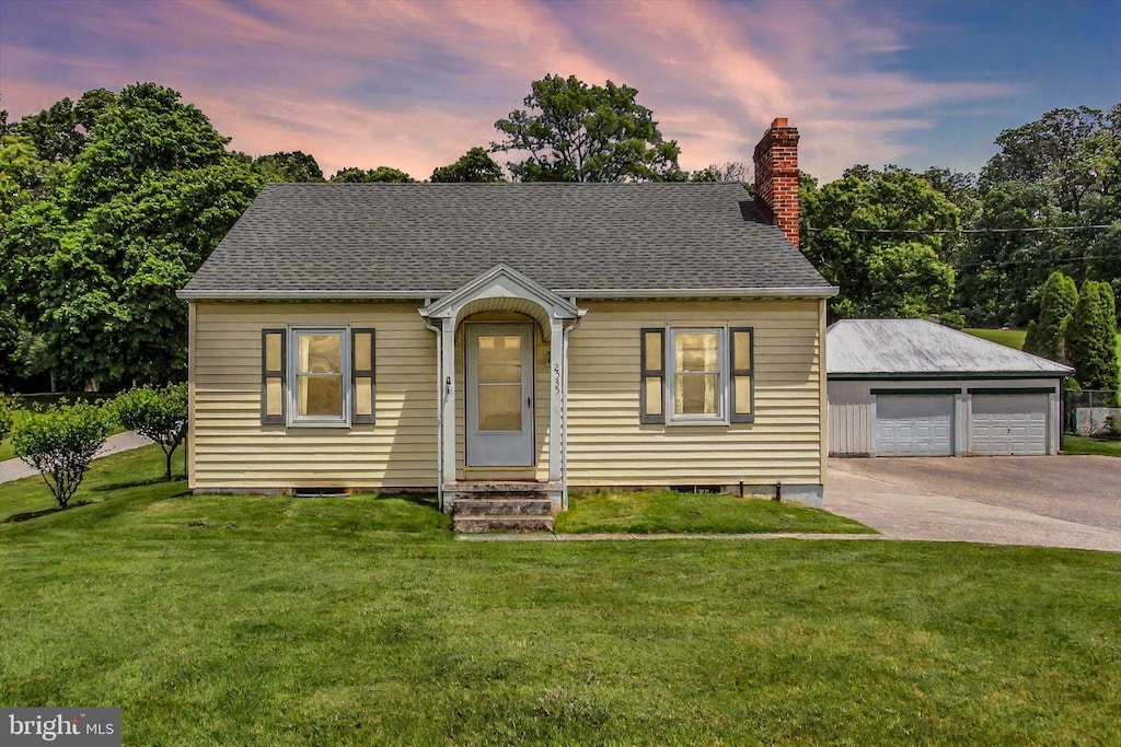2535 Carlisle Pike, Hanover, PA 17331 - view of front facade featuring a chimney, an outdoor structure, a detached garage, a front yard, and a shingled roof