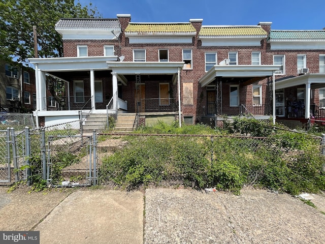3606 Harlem Ave, Baltimore, MD 21229 - townhome / multi-family property featuring a gate, brick siding, a fenced front yard, and covered porch