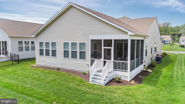 21336 Dauphine St, Lewes, DE 19958 - rear view of property featuring central AC, a sunroom, a yard, and a shingled roof