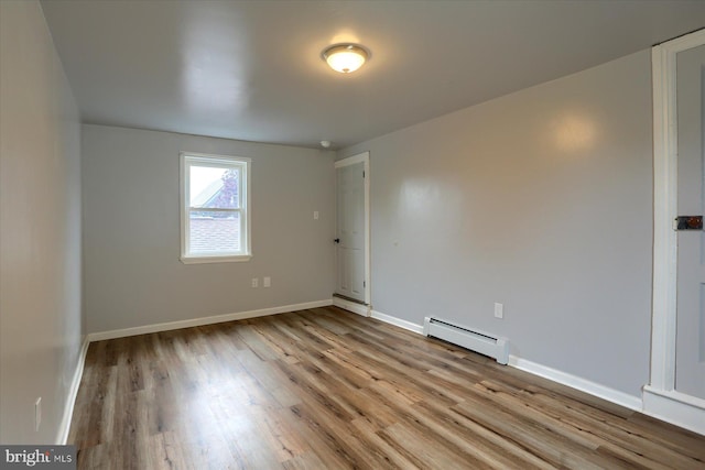 154 S Baltimore St, Dillsburg, PA 17019 - empty room featuring a baseboard heating unit, wood finished floors, and baseboards