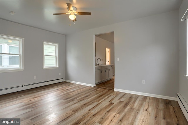 154 S Baltimore St, Dillsburg, PA 17019 - unfurnished room with a baseboard heating unit, a sink, and light wood-type flooring