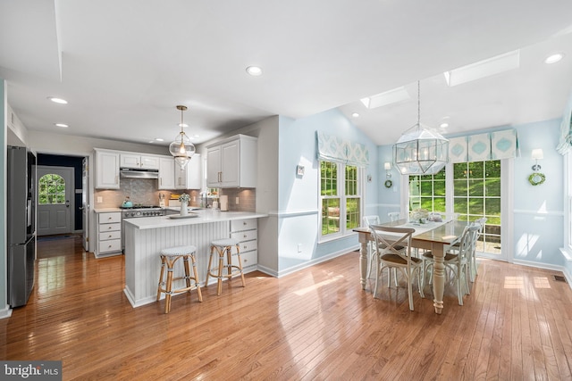 253 Lantern Ln, Gulph Mills, PA 19428 - dining space featuring a skylight, light wood-style flooring, baseboards, recessed lighting, and lofted ceiling