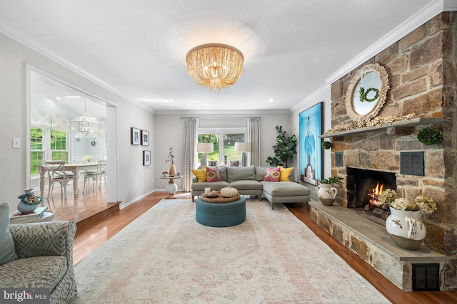 253 Lantern Ln, Gulph Mills, PA 19428 - living room with wood finished floors, a chandelier, ornamental molding, a stone fireplace, and baseboards