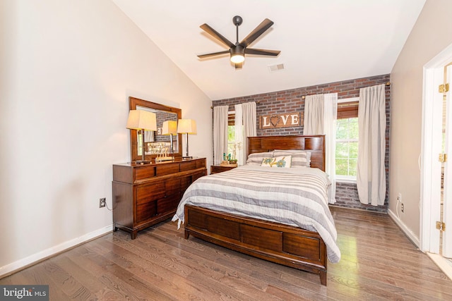 15381 Bronco Way, Woodbridge, VA 22193 - bedroom featuring vaulted ceiling, wood finished floors, baseboards, brick wall, and ceiling fan
