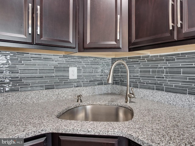 1447 Chatham Ct, Crofton, MD 21114 - kitchen view of a sink, dark brown cabinets, backsplash, and light stone countertops