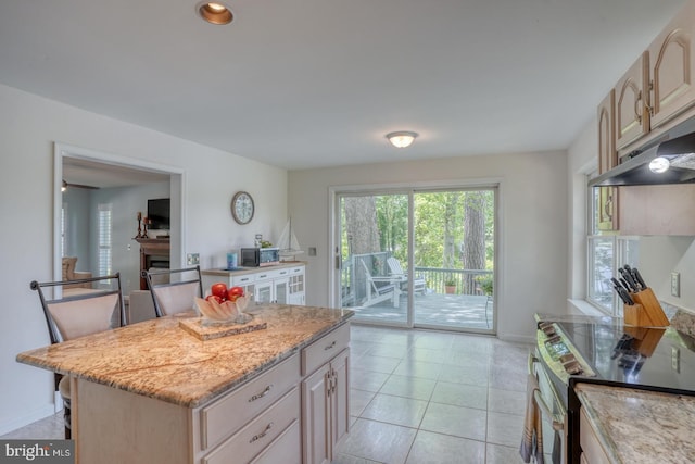 45 S Shore Dr, Dover, DE 19901 - kitchen with stainless steel electric range oven, a fireplace, light stone counters, a center island, and light brown cabinets