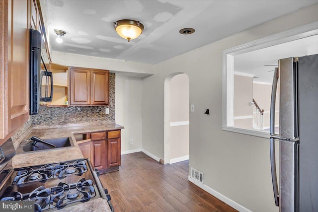7175 Lee Ave, Pennsauken, NJ 08110 - kitchen with freestanding refrigerator, arched walkways, black microwave, light countertops, and open shelves