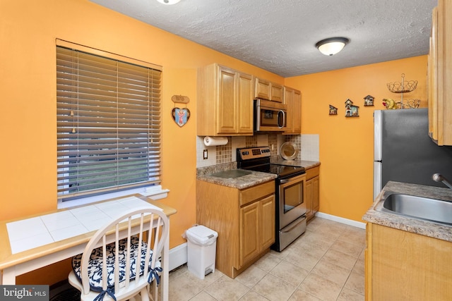 132 The Orchards Unit I, East Windsor, NJ 08520 - kitchen with appliances with stainless steel finishes, a sink, tasteful backsplash, light tile patterned floors, and a textured ceiling