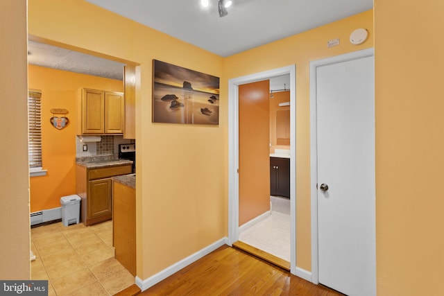132 The Orchards Unit I, East Windsor, NJ 08520 - hallway with baseboards, a baseboard heating unit, and light wood-style floors