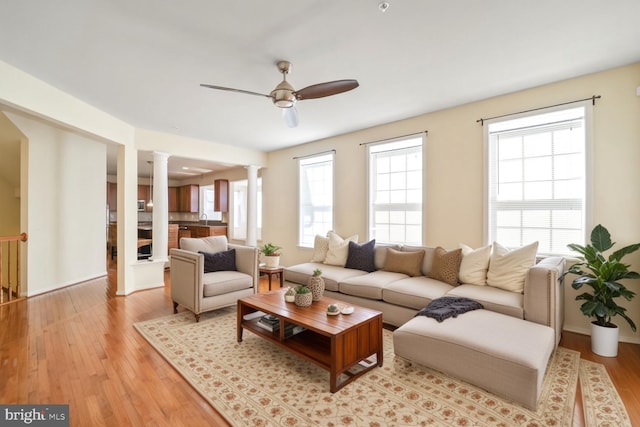 4504 Eden Park Ln, Upper Marlboro, MD 20772 - living room featuring decorative columns, a ceiling fan, and light wood-style flooring