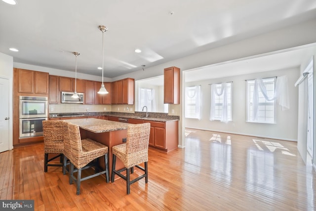 4504 Eden Park Ln, Upper Marlboro, MD 20772 - kitchen featuring stainless steel appliances, a kitchen island, a sink, brown cabinets, and recessed lighting