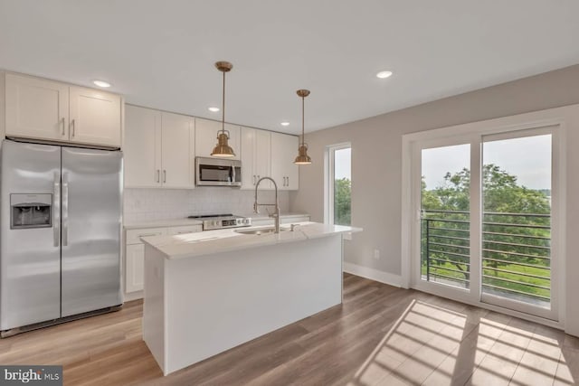 1947 N 33rd St, Philadelphia, PA 19121 - kitchen with appliances with stainless steel finishes, a sink, decorative backsplash, light wood-style floors, and a kitchen island with sink