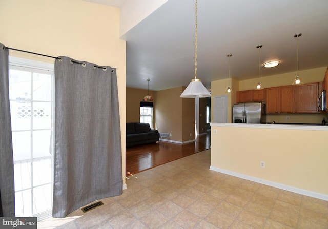 1664 Brynne Ln, Pottstown, PA 19464 - kitchen with stainless steel appliances, brown cabinets, hanging light fixtures, baseboards, and light floors