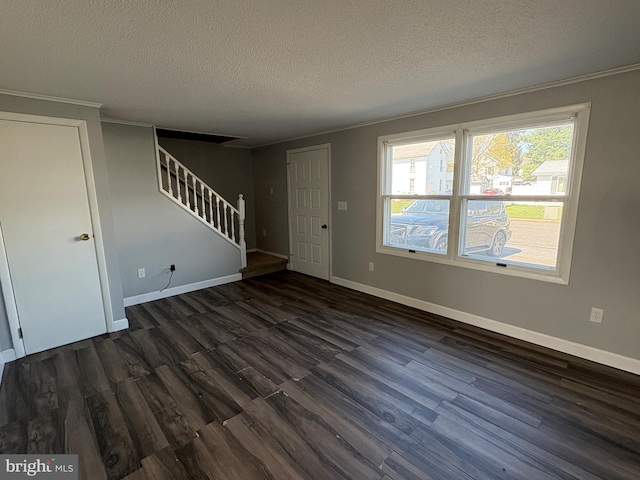 16 W Ninth St, Waynesboro, PA 17268 - unfurnished living room with a textured ceiling, dark wood finished floors, stairway, baseboards, and crown molding