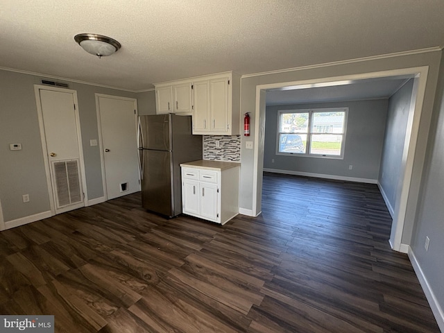 16 W Ninth St, Waynesboro, PA 17268 - kitchen featuring freestanding refrigerator, white cabinets, dark wood finished floors, baseboards, and ornamental molding