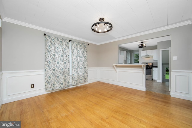 449 Audubon Ave, Audubon, NJ 08106 - unfurnished living room featuring wainscoting, a chandelier, light wood-type flooring, crown molding, and a decorative wall