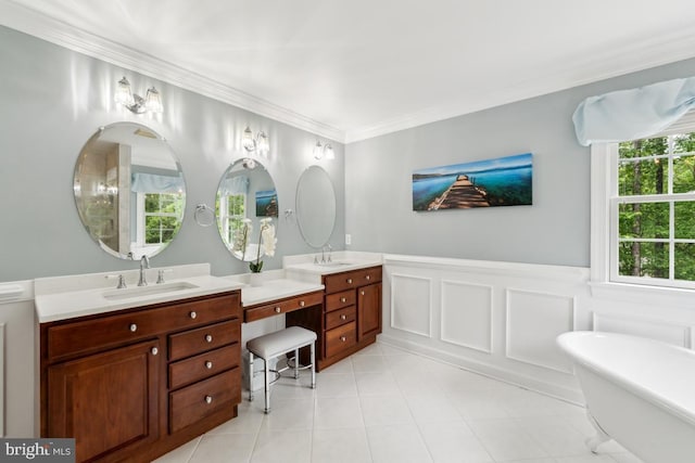 45 Saint Marys Ln, Stafford, VA 22556 - bathroom featuring double vanity, a freestanding tub, wainscoting, crown molding, and tile patterned flooring