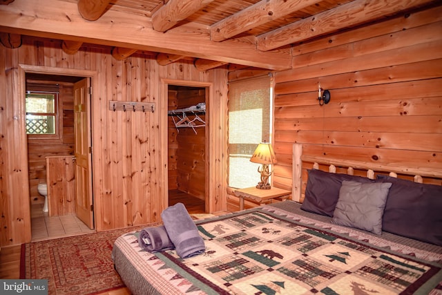 194 Thornberry Ln, Blakeslee, PA 18610 - bedroom with beam ceiling, wooden walls, and connected bathroom