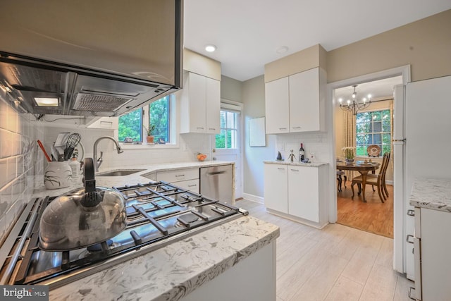 5408 Wehawken Rd, Bethesda, MD 20816 - kitchen with appliances with stainless steel finishes, a chandelier, decorative backsplash, a sink, and white cabinets