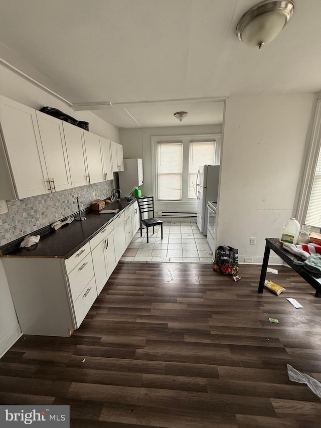 1512 Lindley Ave, Philadelphia, PA 19141 - kitchen with dark countertops, freestanding refrigerator, light wood-style floors, white cabinets, and backsplash