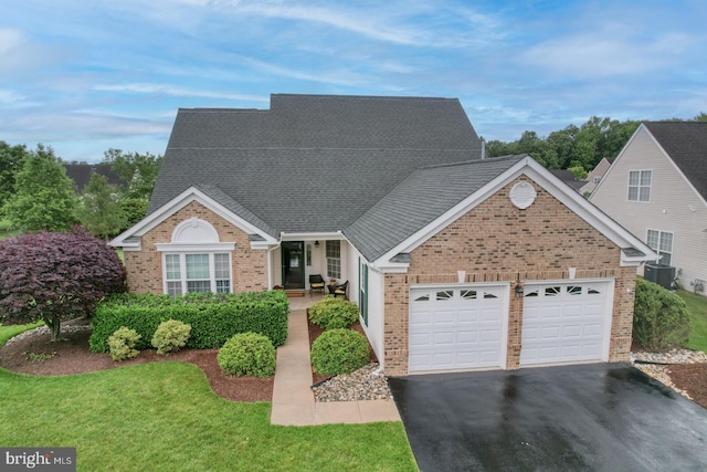 73 Springmill Dr, Middletown, DE 19709 - view of front of property featuring brick siding, a garage, asphalt driveway, and central air condition unit