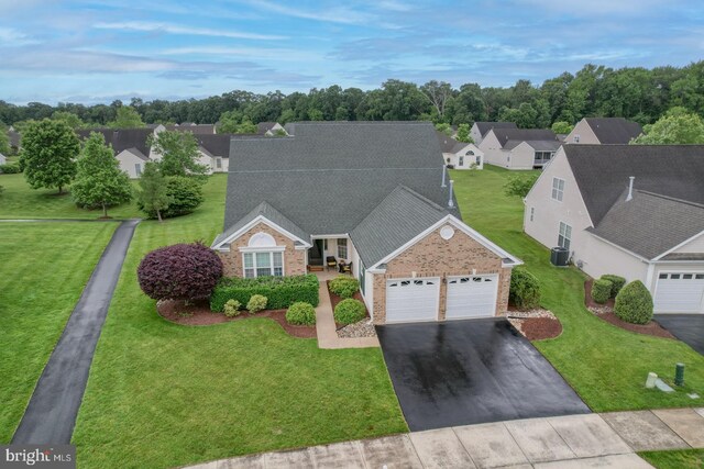 73 Springmill Dr, Middletown, DE 19709 - view of front of home with brick siding, an attached garage, asphalt driveway, and central air condition unit
